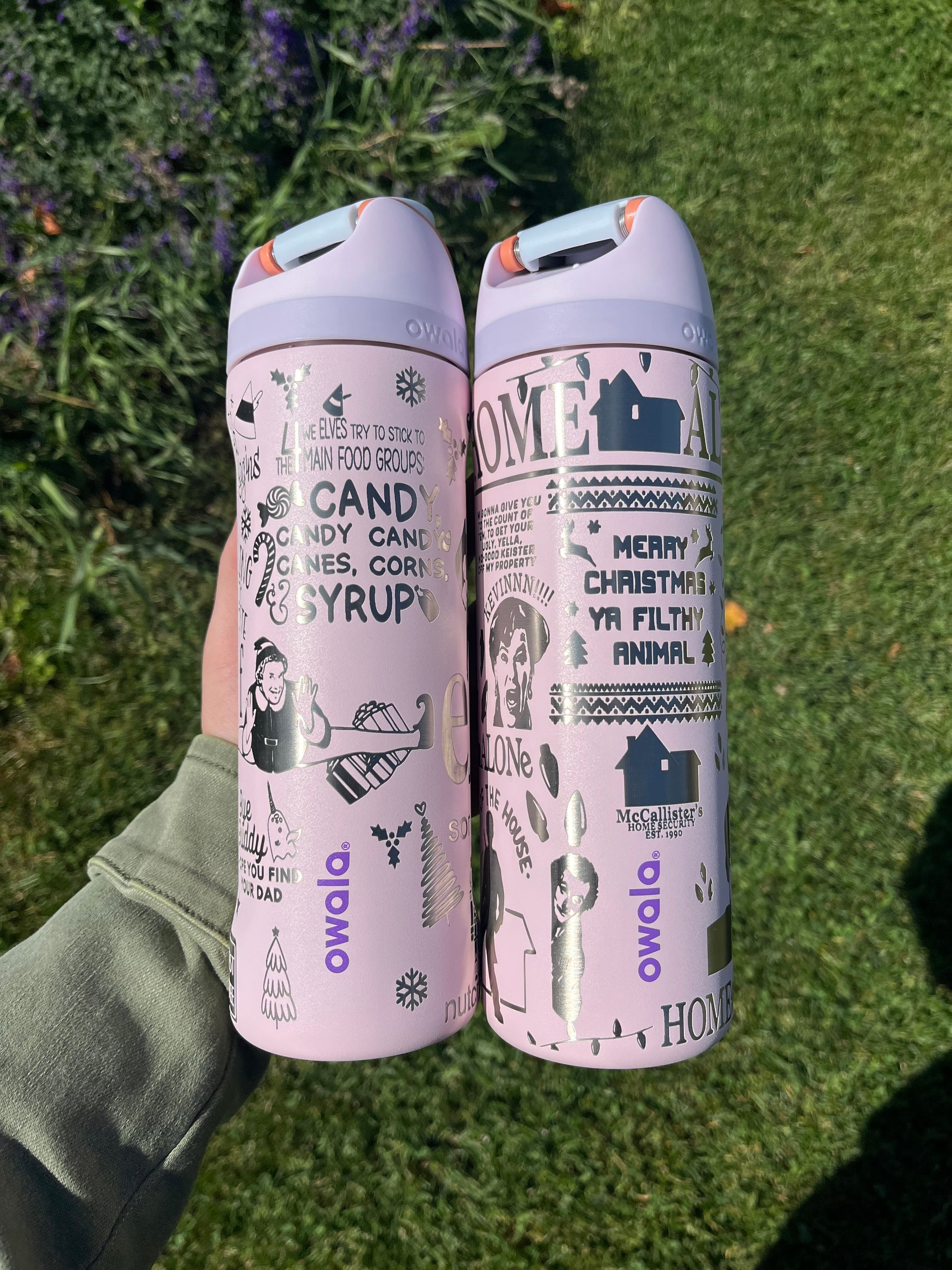 Two pink cylindrical products with text and graphics on a grassy background