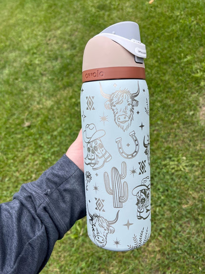 Western Owala FreeSip tumbler engraved with highland cow, boots, flowers, and Aztec design
