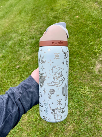 Western Owala FreeSip tumbler engraved with highland cow, boots, flowers, and Aztec design