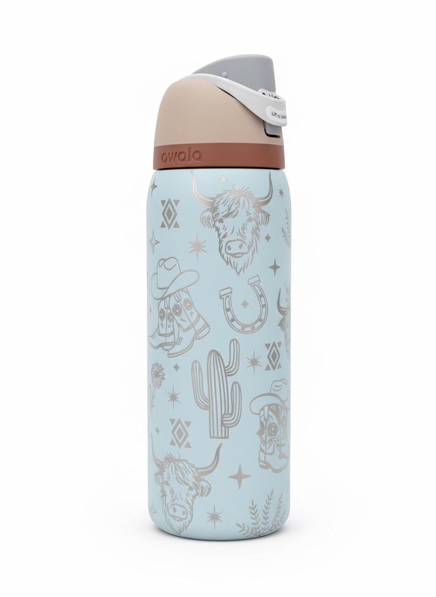 Western Owala FreeSip tumbler engraved with highland cow, boots, flowers, and Aztec design