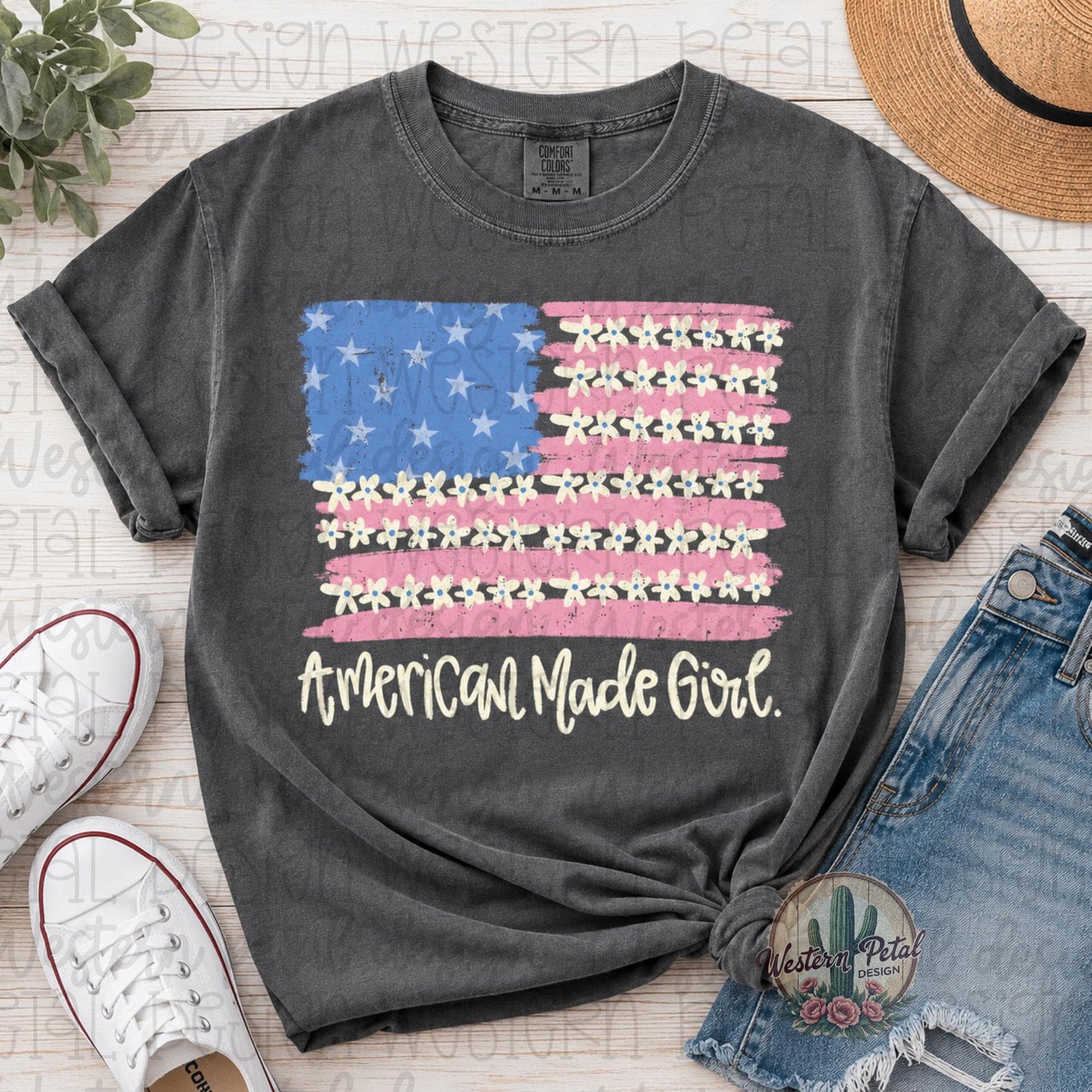 Comfort Colors 1717 pepper gray t-shirt featuring a distressed American flag design with daisy flowers and “American Made Girl” text in cream lettering.