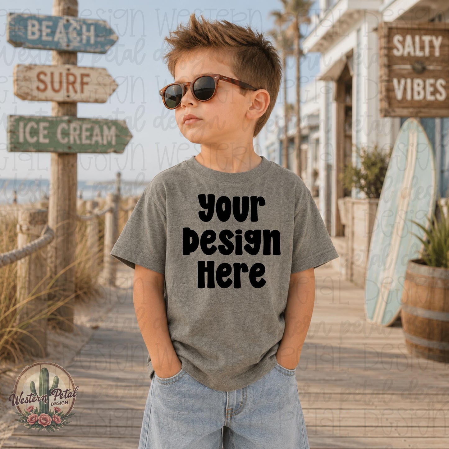 Little boy wearing a Bamboo Blackout Rabbit Skins t-shirt mockup standing on a beach boardwalk with coastal summer decor and surf signs.