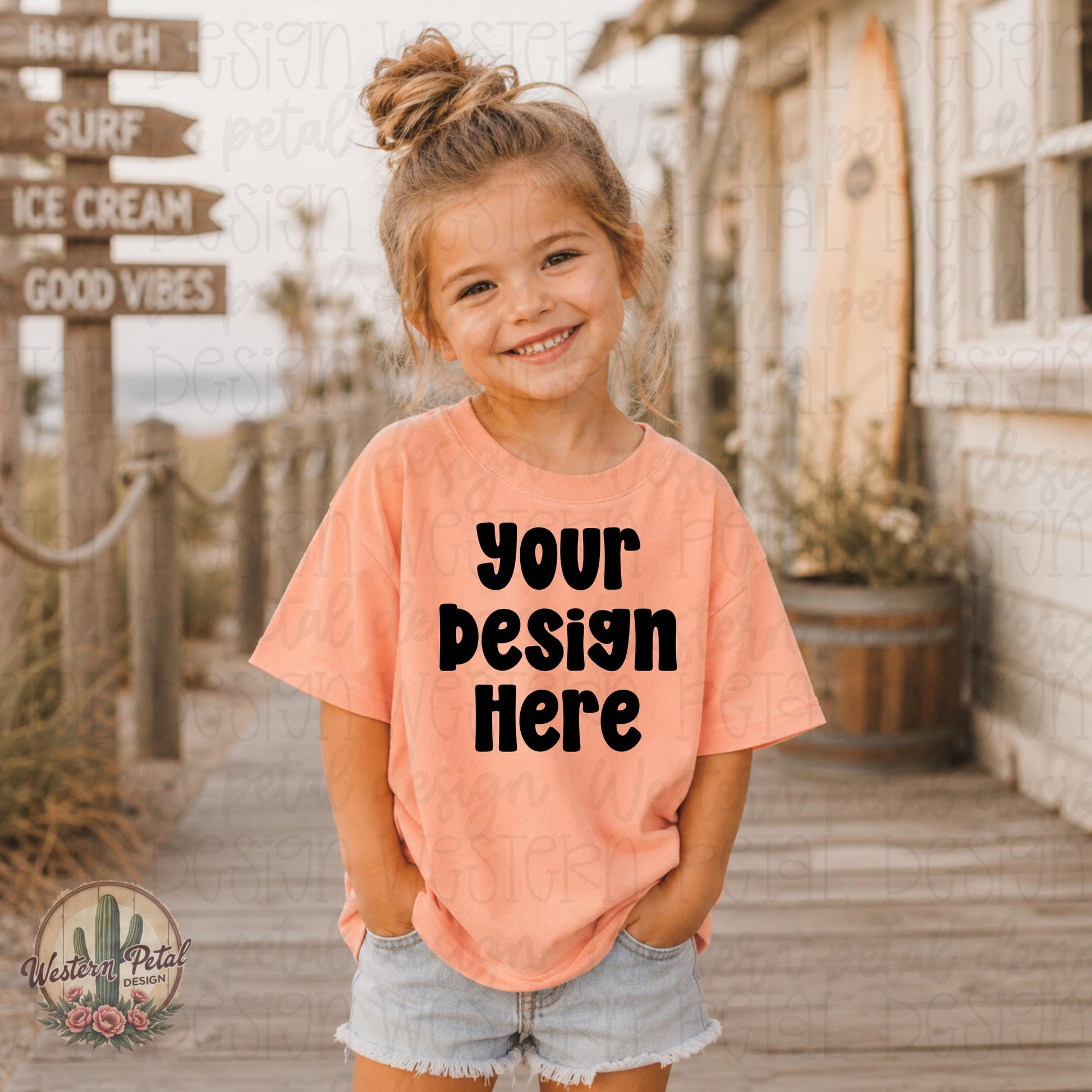 Smiling little girl wearing a peach Rabbit Skins t-shirt mockup on a beach boardwalk with coastal summer decor and surf inspired background.