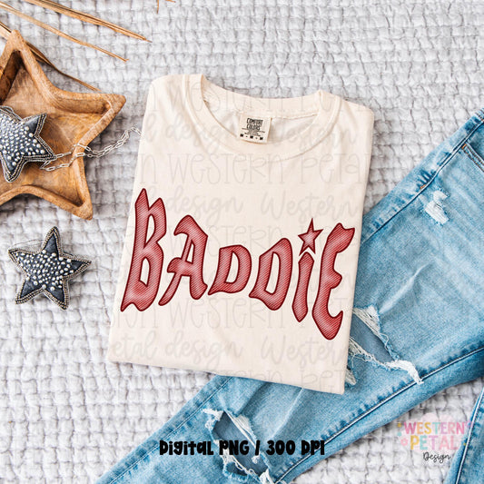 Folded ivory Comfort Colors shirt mockup with red hand drawn “Baddie” western style lettering beside distressed denim jeans and western star accessories.