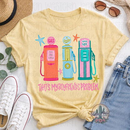 Comfort Colors 1717 butter yellow t-shirt featuring colorful retro gas pumps with the phrase “That’s My Boyfriend’s Problem” in pink lettering.
