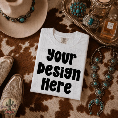 White Comfort Colors folded shirt mockup styled on western cowhide rug with cowboy hat boots and neutral western decor