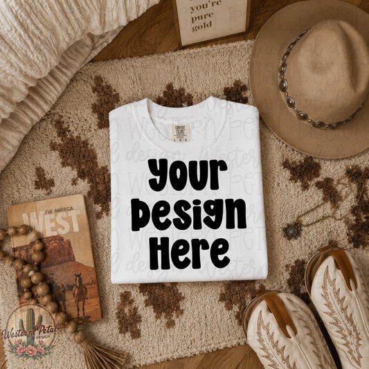 White Comfort Colors folded shirt mockup styled on western cowhide rug with cowboy hat boots and neutral western decor