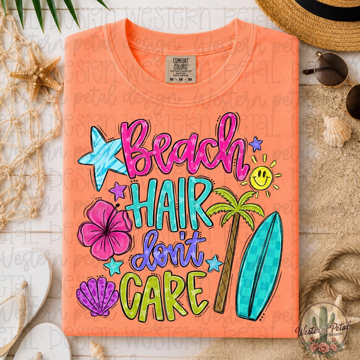 Folded neon cantaloupe Comfort Colors 1717 shirt with colorful “Beach Hair Don’t Care” tropical graphic in a coastal beach flat lay scene with shells, sunglasses, and straw hat.