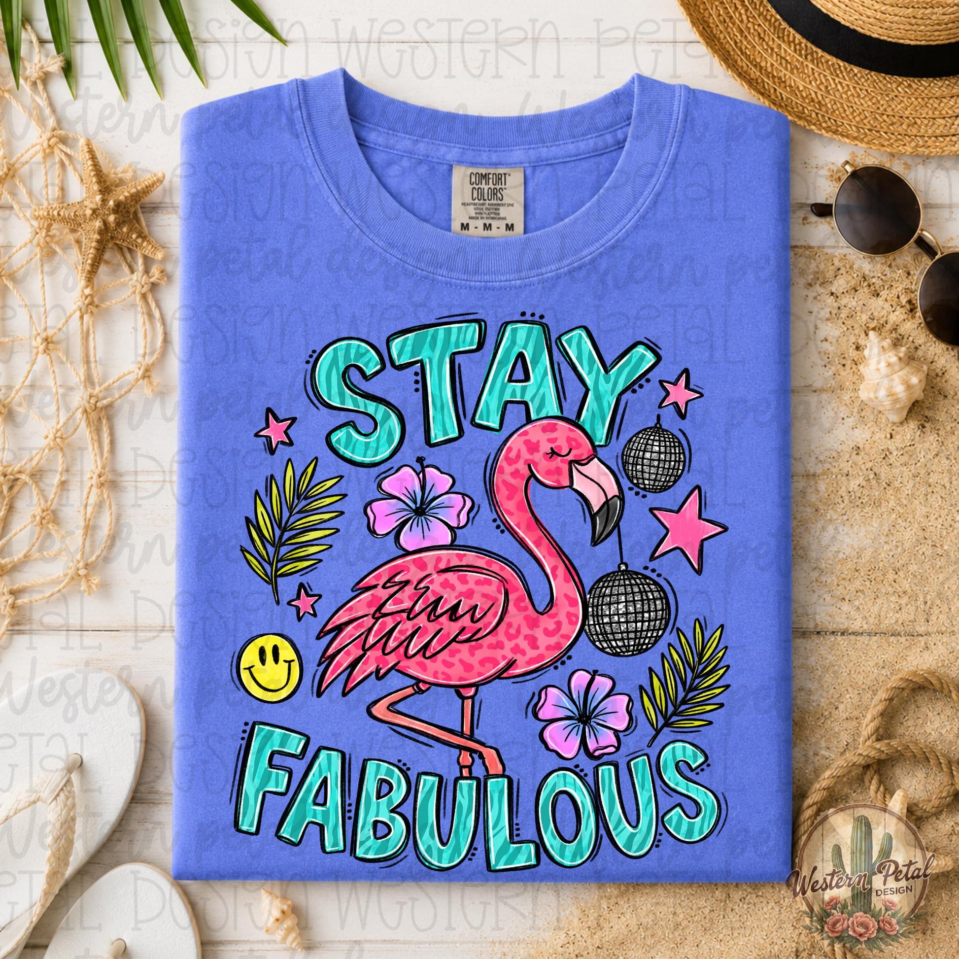 Flo Blue Comfort Colors 1717 graphic tee featuring a pink flamingo with “Stay Fabulous” text in a trendy tropical flat lay mockup with boho beach decor.