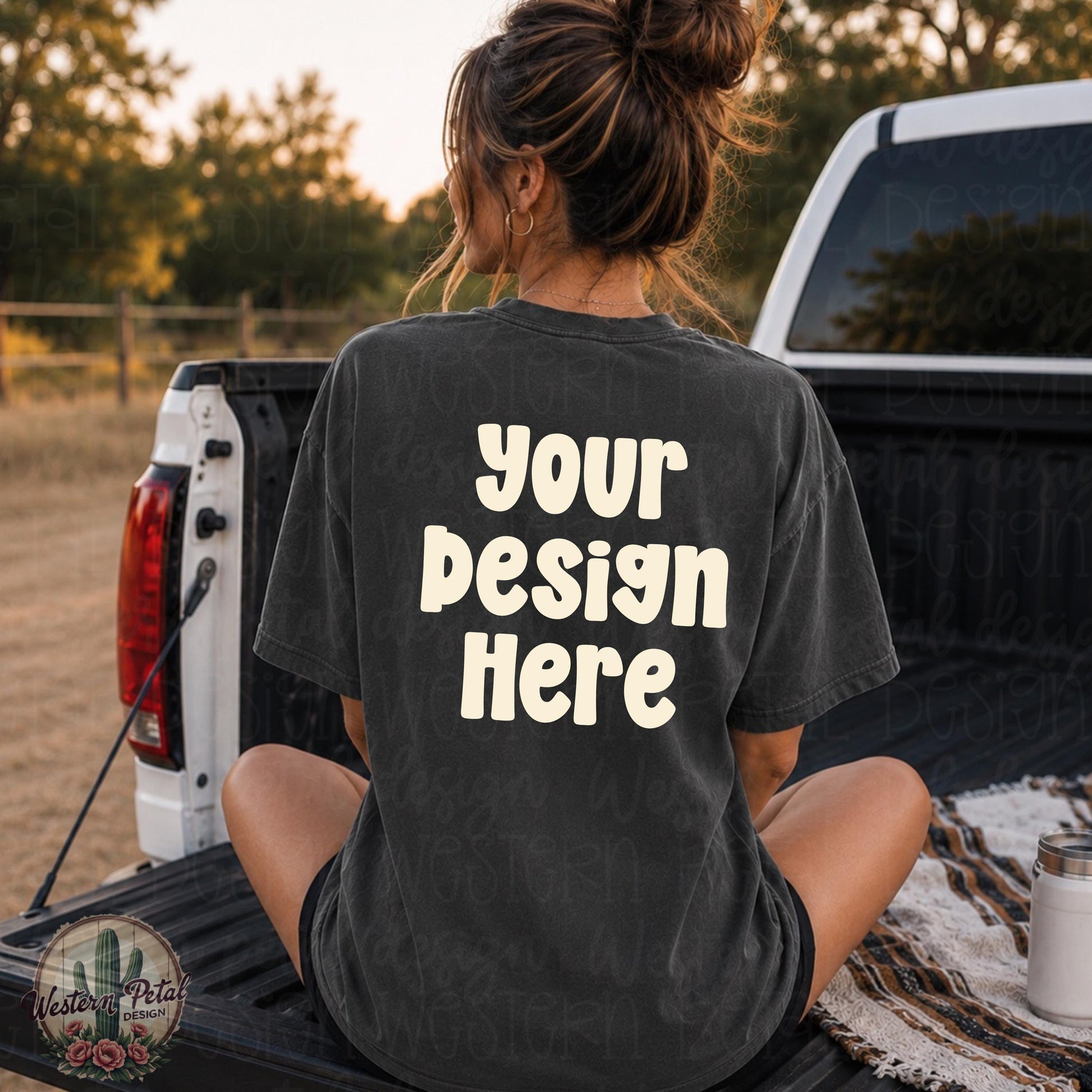 Woman sitting in the back of a pickup truck wearing a Comfort Colors 1717 pepper shirt mockup with oversized back design placement and trendy western outdoor aesthetic.